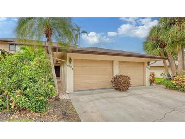 Two-car garage with paved driveway and lush landscaping at 6724 Schooner Bay Cir # 6724, Sarasota, FL 34231