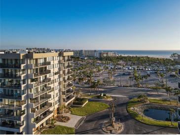 Aerial view of a condo building with ocean views, parking, and lush landscaping at 1055 Beach Rd # B-302, Sarasota, FL 34242