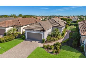 Single-story home with gray garage door and landscaped yard at 8720 Bellussi Dr, Sarasota, FL 34238