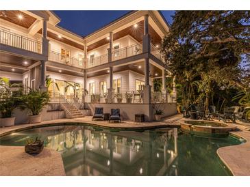 Luxury waterfront home with expansive pool and spa, plus stunning nighttime exterior at 1243 Starboard Ln, Sarasota, FL 34242