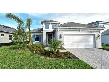 Two-story house with gray exterior, white garage door, and landscaped yard at 2528 Star Apple Way, Sarasota, FL 34240