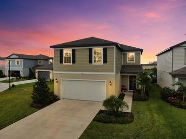 Two-story house with attached garage and landscaped front yard at 8220 Reefbay Cv, Parrish, FL 34219