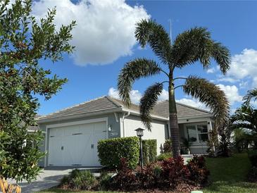 House exterior featuring a two-car garage and landscaping at 1045 Crosswind Ave, Sarasota, FL 34240