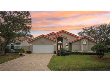 Tan house with orange roof, white garage door, and landscaped lawn at 5296 White Sand Ne Cir, St Petersburg, FL 33703