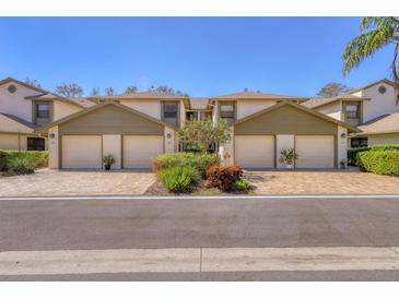 Three-unit condominium building with attached garages and lush landscaping at 1676 Starling Dr # 202, Sarasota, FL 34231