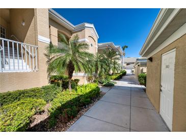 Exterior walkway leading to condo building with landscaping at 6311 Grand Oak Cir # 202, Bradenton, FL 34203