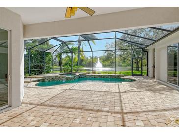 Spacious pool area with covered patio, overlooking a tranquil lake at 7816 Crest Hammock Way, Sarasota, FL 34240