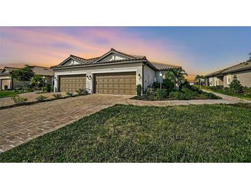 Two-car garage, paver driveway, and landscaped lawn at 4734 Tortona Ct, Bradenton, FL 34211