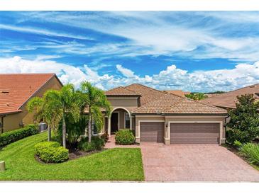 Single-story home with tile roof, brick driveway, and lush landscaping at 11192 Whimbrel Ln, Sarasota, FL 34238