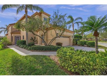 Tan two-story home with garage and manicured landscaping at 4028 Mira Lago Dr, Sarasota, FL 34238