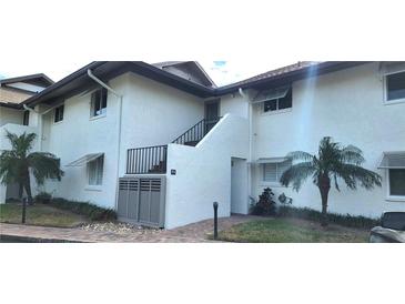 Front view of a light-colored building with stairs and landscaping at 4234 Gulf Of Mexico Dr # Y2, Longboat Key, FL 34228