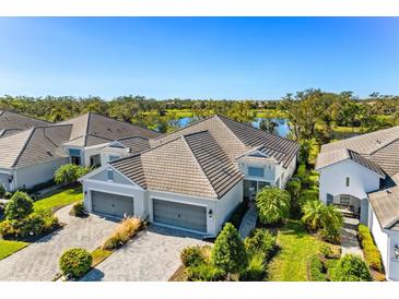 Stunning home with a two-car garage, lush landscaping, and a serene water view at 3028 Sky Blue Cv, Bradenton, FL 34211