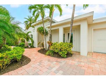 Bright, inviting exterior with a paved walkway, lush landscaping, and palm trees at 1954 Datura St, Sarasota, FL 34239