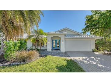 Charming single-story home with vibrant blue double-door entry, manicured landscaping, and a convenient two-car garage at 435 Partridge Cir, Sarasota, FL 34236