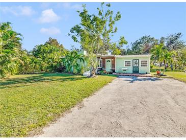 Light green house with a spacious lawn and driveway at 2910 49Th St, Sarasota, FL 34234