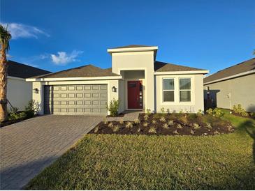 New single-story home with gray garage door and red front door at 16105 Old Fox Trl, Port Charlotte, FL 33953