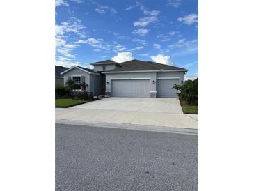 Two-story house with a three-car garage and landscaped yard at 16721 Barnwood Pl, Bradenton, FL 34211