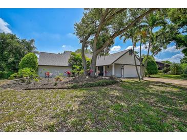 Charming one-story home featuring a beautiful yard with mature trees and lush landscaping at 5373 Dominica Cir, Sarasota, FL 34233