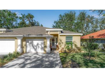 Front view of charming house with two-car garage and manicured lawn at 128 51St Street E Cir # 7, Palmetto, FL 34221