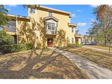 Tan two-story townhome with red garage doors and walkway at 4990 Baraldi Cir # 101, Sarasota, FL 34235