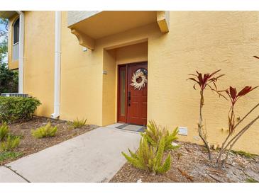 Townhouse exterior with a red door and well-maintained landscaping at 4990 Baraldi Cir # 101, Sarasota, FL 34235