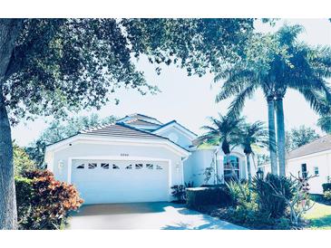 Single-story home with gray exterior, tile roof, and landscaped yard at 5200 Highbury Cir, Sarasota, FL 34238