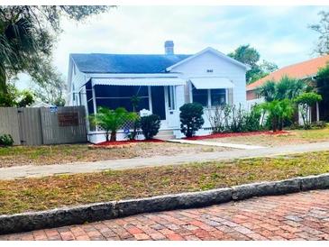 Charming bungalow with white exterior, landscaping, and brick walkway at 3642 Dartmouth N Ave, St Petersburg, FL 33713