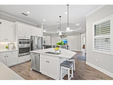 Open concept kitchen with island, stainless steel appliances, and white cabinetry at 13021 Indigo Way, Bradenton, FL 34211