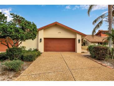 Front view of charming single-story home with attached garage and well-manicured landscaping at 6105 Courtside Dr, Bradenton, FL 34210