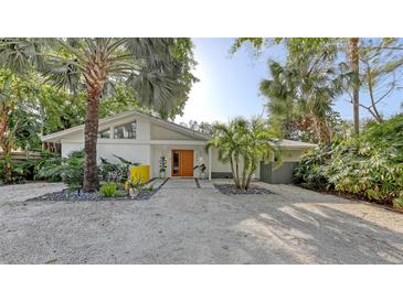 Mid-century modern home with landscaped yard and a white exterior at 4844 Brywill Cir, Sarasota, FL 34234