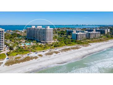 Aerial view of beachfront condo building with pool and tennis courts at 1211 Gulf Of Mexico Dr # 706, Longboat Key, FL 34228