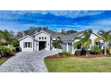 Beautiful two-story home with gray stone accents and a lush, landscaped yard at 16026 39Th E Gln, Parrish, FL 34219