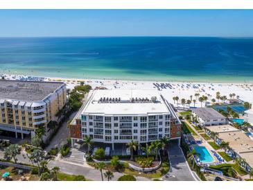 Aerial view of a modern condominium complex on a pristine white sand beach with clear blue ocean views at 1035 Seaside Dr # 305, Sarasota, FL 34242