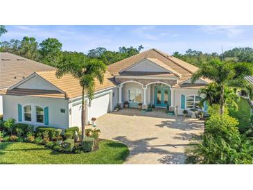 Stunning single-story home with a tile roof, teal accents, and lush landscaping at 7168 Ryedale Ct, Sarasota, FL 34241