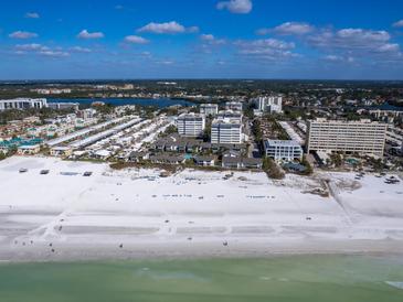 Aerial view of beachfront property, showing community, beach, and ocean at 1080 W Peppertree Ln # 506A, Sarasota, FL 34242
