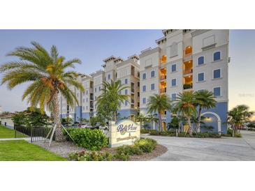 Beautiful condo building featuring a branded sign, palm trees, well-maintained landscaping, and colorful facade at 505 Tamiami N Trl # 201, Venice, FL 34285