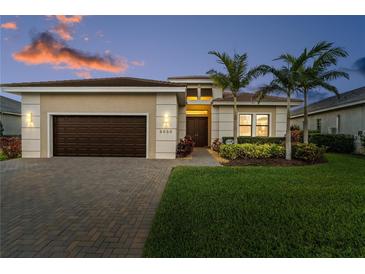 Inviting single-story home boasts lush landscaping, a paver driveway, and a two-car garage at 5050 Surfside Cir, Lakewood Ranch, FL 34211