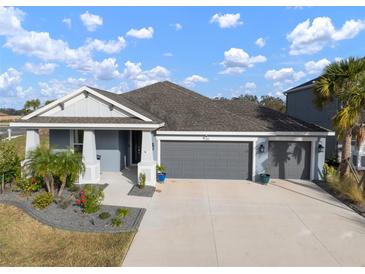 Two-story home with gray exterior, three car garage, and landscaped yard at 11160 Fieldstone Dr, Palmetto, FL 34221