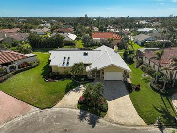 Aerial view of a single-Gathering home with a large yard and paved driveway at 219 Keel Way, Osprey, FL 34229