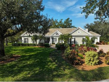 Beautiful one-story home with lush landscaping and a large lawn at 85 Sugar Mill Dr, Osprey, FL 34229