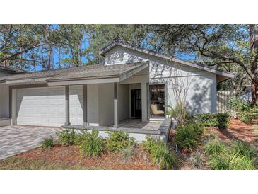 Updated exterior featuring a two-car garage and landscaped grounds at 4720 Oak Forest W Dr # 57, Sarasota, FL 34231