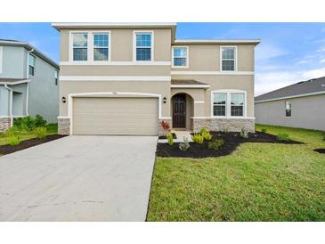 Two-story house with a neutral color scheme, two-car garage, and landscaped yard at 5316 Rocky Coast Place, Palmetto, FL 34221