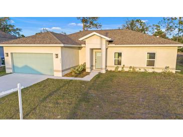 New construction home with a light-colored exterior, a two-car garage, and a grassy lawn at 2842 Escambia Cir, North Port, FL 34288