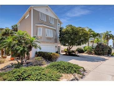 Two-story home with a landscaped yard and driveway at 5392 Gulf Dr, Holmes Beach, FL 34217