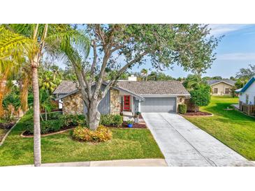 Ranch style home with gray exterior, red door, and landscaped yard at 6609 Waterford Ln, Sarasota, FL 34238