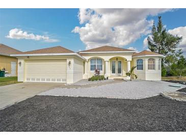 Single-story house with attached garage,light-colored exterior, and landscaped yard at 15124 Leipzig Cir, Port Charlotte, FL 33981