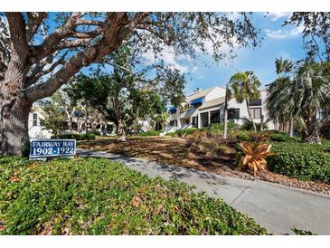 Fairway Bay condos showcasing lush landscaping, mature trees and white buildings with blue accents at 1912 Harbourside Dr # 603, Longboat Key, FL 34228