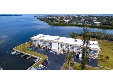 Aerial view of waterfront condo building with parking and boat slips at 3330 Gulf Of Mexico Dr # 205D, Longboat Key, FL 34228