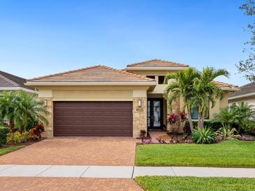 Single-story home with brown garage door, landscaping, and brick driveway at 4925 Surfside Cir, Bradenton, FL 34211