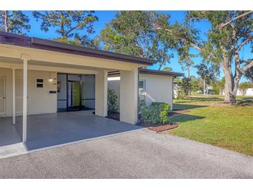 Condo exterior featuring carport and landscaped lawn at 6100 Greenview Dr # 145, Sarasota, FL 34231